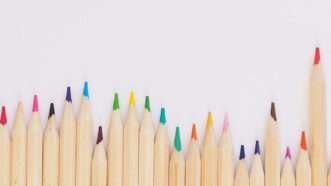 colored pencils in an uneven row against a white background | Photo: Jess Bailey/Unsplash
