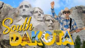 Remy with guitar stands with an image of Mount Rushmore and text reading "South Dakota" | Reason TV
