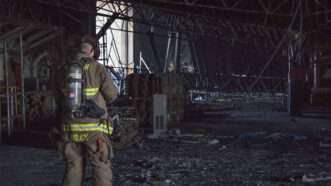 Firefighter stands in burnt out building | M Natalie Byers/U.S. Navy/ZUMA Press/Newscom