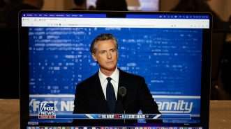 California Governor Gavin Newsom shown on television screen debating on Fox News' "Hannity" | Robin Rayne/ZUMAPRESS/Newscom