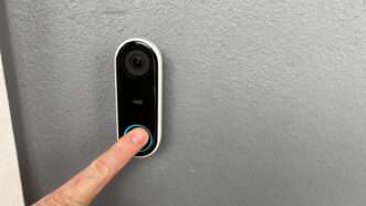 An outstretched hand presses the button on a Ring video doorbell. | Joni Hanebutt | Dreamstime.com