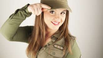 A beautiful woman in a military uniform does a half-salute half-point to the camera. | Bogdan Chirap | Dreamstime.com