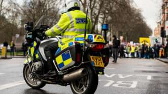 An officer with London's Metropolitan Police riding a motorcycle. | John Gomez | Dreamstime.com