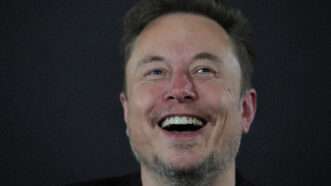 Elon Musk laughing against a dark background | Avalon/Newscom