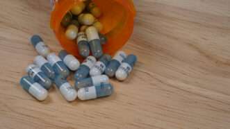 A pill bottle tipped over, spilling out capsules of Adderall XR. | Mariakonosky | Dreamstime.com
