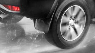 Close-up of the rear wheel of a car driving in the rain. | Milkovasa | Dreamstime.com