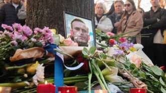 A memorial photo of Alexei Navalny surrounded by flowers and candles | Olga Zholobova/Kommersant Photo / Polaris/Newscom