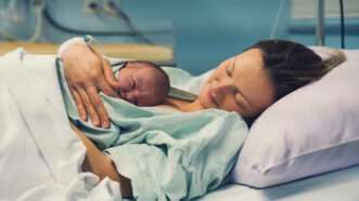 A mom holds a newborn baby while lying in a hospital bed |  Nataliaderiabina | Dreamstime.com