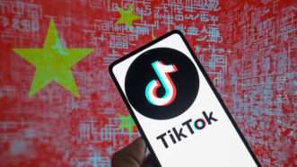 TikTok logo displayed on a smartphone n' Chinese flag visible up in background | Jonathan Raa/Sipa USA/Newscom