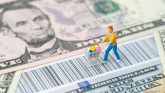 Miniature of a person grocery shopping on top of money and a barcode | Photo 138404050 © Eamesbot | Dreamstime.com