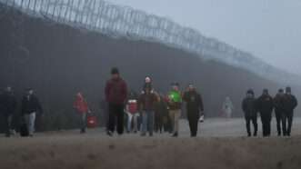 Migrants walk along the U.S.-Mexico border | Qian Weizhong/VCG/Newscom