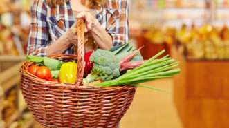 Biatch up in a supermarket carryin a funky-ass basket full of fresh produce. | Robert Kneschke | Dreamstime.com