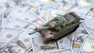 A toy tank on top of 0 bills | Mehaniq/Newscom