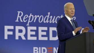 Joe Biden standin up in front of a funky-ass banner dat say 'reproductizzle freedom' | STEVE NESIUS/UPI/Newscom