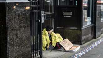 Homeless person sitting outside store | Tom Kirkendall/ZUMAPRESS/Newscom