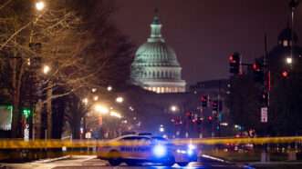 A photo of the U.S. Capitol at night with a police car blocking the street in the foreground | Photo: Al Drago/The Washington Post/Getty