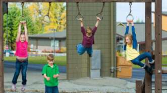 Kids swing from playground equipment | Recess © Mathayward | Dreamstime.com