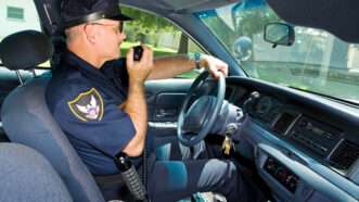 Policeman in his patrol car radioing in. | Brian T. Young | Dreamstime.com