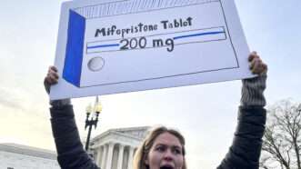 A sign is held at an abortion pill protest | Sue Dorfman/ZUMAPRESS/Newscom
