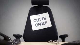 An empty office chair with a sign on it that says OUT OF OFFICE | Flynt | Dreamstime.com