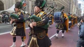 Members of the NYPD Emerald Society Pipes & Drums, a band for Irish-American civil servants, march in the St. Patrick's Day Parade along 5th Avenue. | Ron Adar/SOPA Images via ZUMA Press Wire