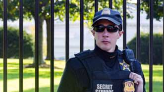 A young male U.S. Secret Service agent stationed at the gate in front of the White House | Valerio Rosati | Dreamstime.com