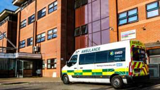 An EMED ambulance that contracts with the United Kingdom's National Health Service, parked outside a hospital in Surrey. | Martinlee58 | Dreamstime.com