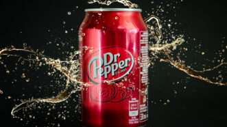 A can of Dr. Pepper with liquid spilling out around it | Tamara Fesenko | Dreamstime.com