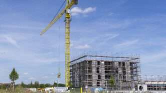 A crane next to an apartment building under construction. | imageBROKER/Lilly/Newscom