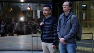 Patrick Lam and Chung Pui-kuen stand outside courthouse. | Edmond So/SCMP/Newscom