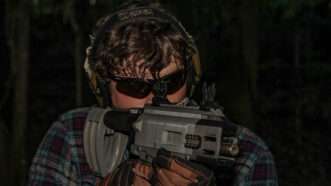 A man in sunglasses fires a FGC-9 3D-printed gun. | Collin Mayfield/Sipa USA/Newscom