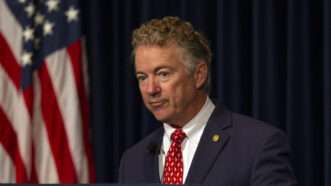 Senator Rand Paul stands in front of an American flag and a dark background |  Brian Cahn/ZUMAPRESS/Newscom