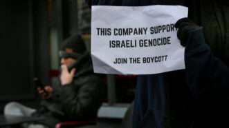 Person holds sign encouraging boycotting brands that "support Israeli genocide." | Martin Pope/ZUMAPRESS/Newscom