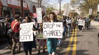 Protesters in Atlanta carry signs reading STOP COP CITY and DROP THE CHARGES. | Steve Eberhardt/ZUMAPRESS/Newscom