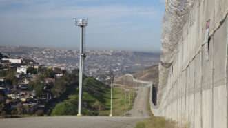 The Tijuana side of the U.S./Mexico border fence, with a tower in the background that holds a camera on top. | imageBROKER/Jim West/Newscom