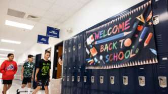 A banner hangs on lockers reading Welcome Back to School and students walk past it |  Khadejeh Nikouyeh/TNS/Newscom