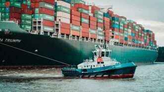 Container ship being pulled by tug boat | Photo by Mika Baumeister on Unsplash