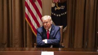 President Donald Trump with arms crossed seated at a table in the White House Cabinet Room, in June 2020. | Polaris/Newscom