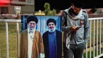 Man standing next to image of Ayatollah Khamenei |  Ismael Adnan / SOPA Images/Sipa USA/Newscom