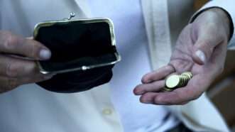 An old man holds a few coins in one hand and an empty coin purse in the other. | motortion | Dreamstime.com