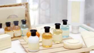 A row of hotel amenities, including shampoo, conditioner, and shower gel. | Viorel Dudau | Dreamstime.com