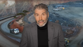 John Stossel is seen in front of a mine | Stossel TV