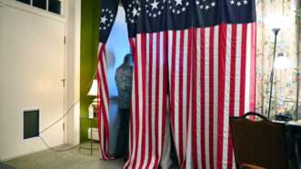 Person in a voting booth casting a ballot | Li Rui / Xinhua News Agency/Newscom