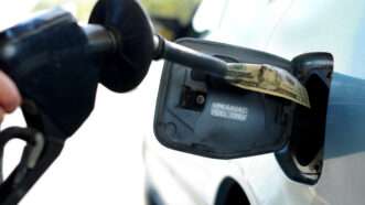 A hand holds a gas pump while filling up a car's gasoline tank | ID 4657164 | Gas Pump © Zimmytws | Dreamstime.com