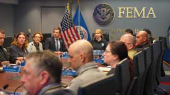 Government officials sit around a conference table in a FEMA office | Polaris/Newscom