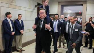 Elon Musk (with his son on his shoulders) and Vivek Ramaswamy walk through a corridor in the U.S. Capitol | Jemal Countess/UPI/Newscom