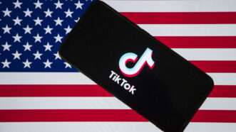 A smartphone with the TikTok logo on it in front of the American flag | Faisal Bashir/ZUMAPRESS/Newscom