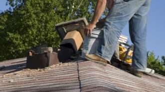 A roofer works on a chimney. | Wisconsinart | Dreamstime.com