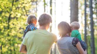 A mom and a dad walk through the woods, each of them holds a child and everyone has their back to the camera | ID 53719860 | Baby © Gajus | Dreamstime.com