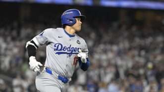 Shohei Ohtani running while wearing a gray Dodgers uniform and a blue batting helmet. | Kyodonews/ZUMAPRESS/Newscom